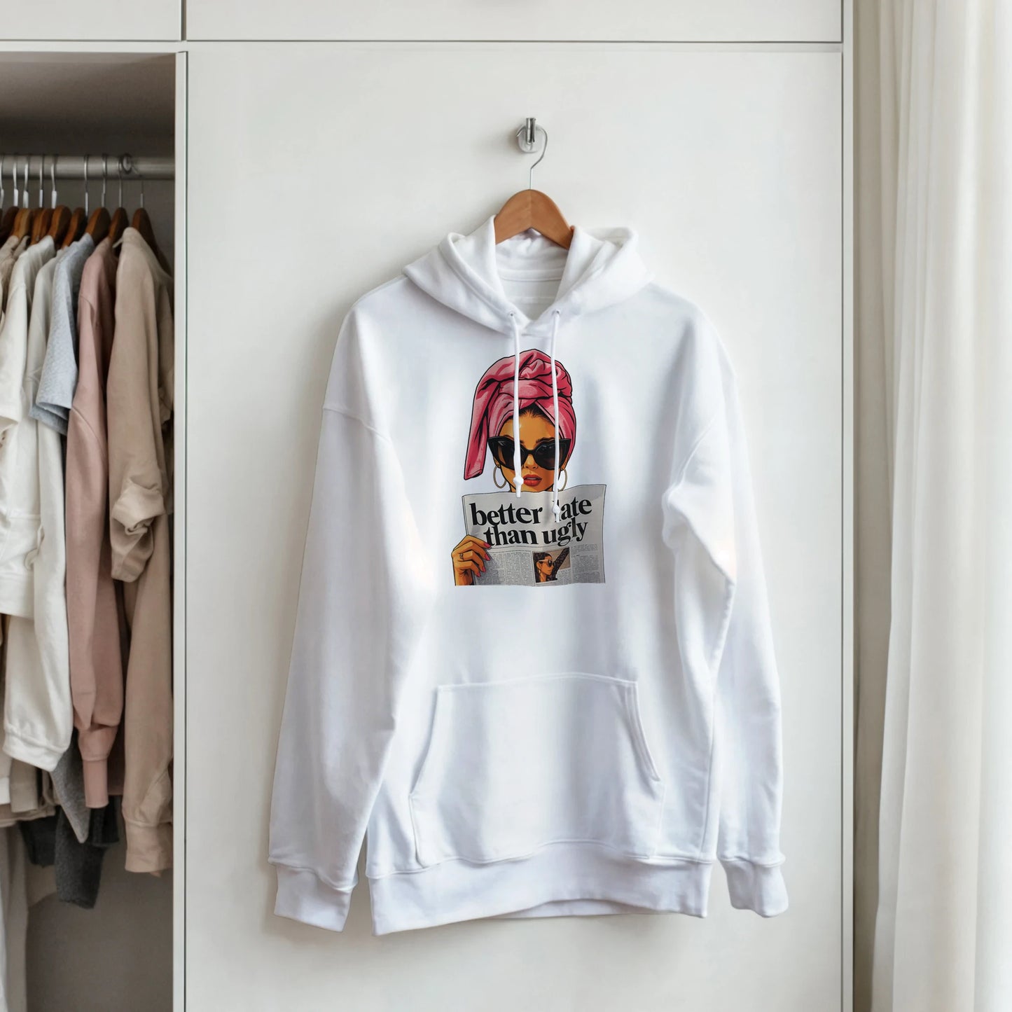 White hoodie with graphic design hanging in a closet
